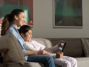 A mother and her daugther reading a webpage with Immersive Reader in Microsoft Edge. The Acer Travelmate B311 2-in-1 is in tablet mode. Remote Learning collection. Keywords: remote education, remote learning, home school, study from home
