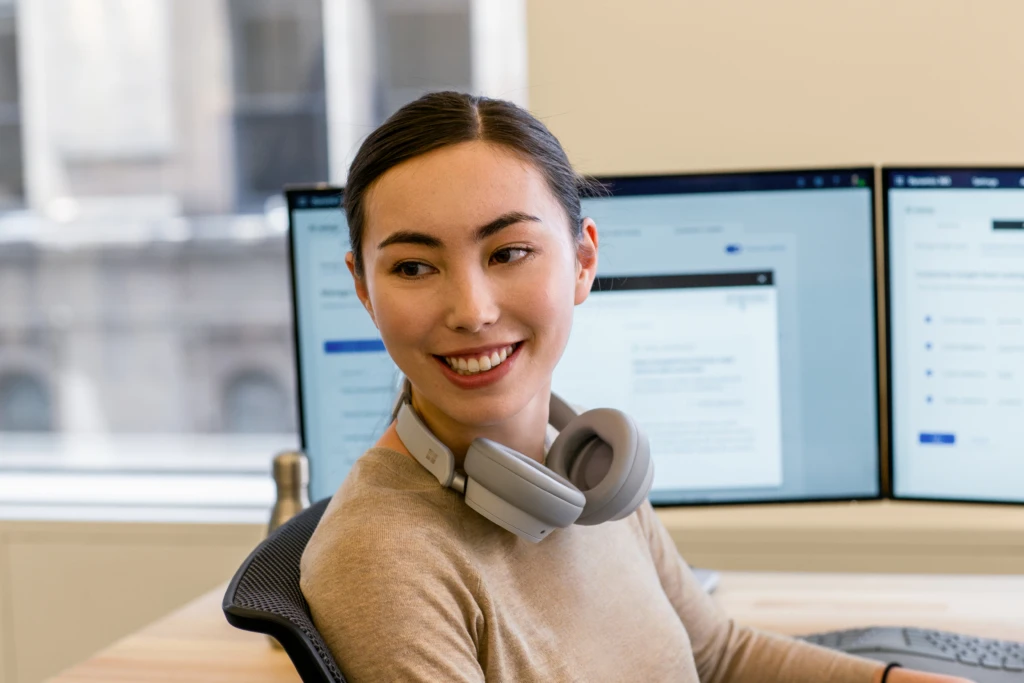 Engineer informal portrait. A female smiling with headphones around her neck.