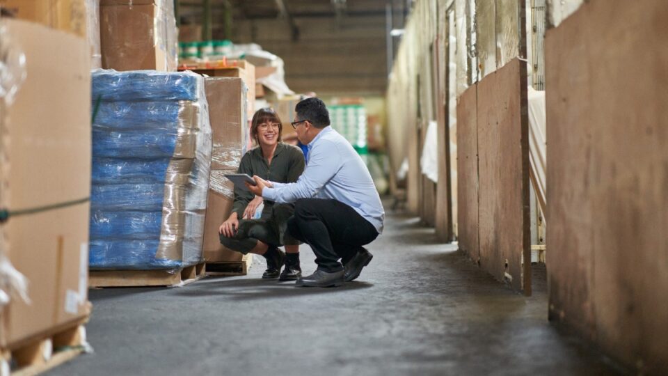 CEO and COO of a textile manufacturing plant working together on the warehouse floor.