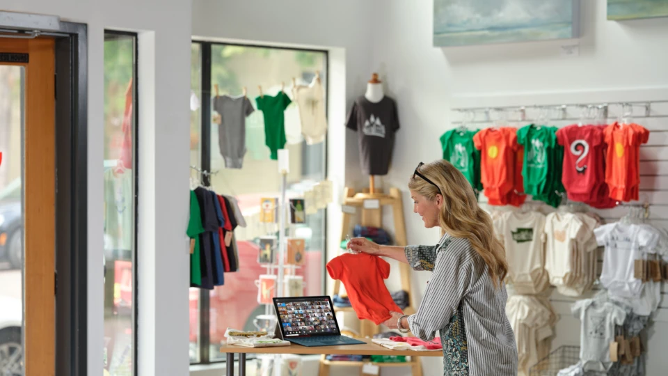 Retail shop owner selling onsie to virtual customers on Microsoft Teams. 7x7 Teams Female, video, call, retail, clothing, shop, baby, onsie, remote, Covid, pandemic