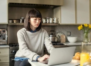 Female working on laptop in kitchen