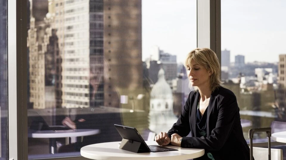 Business woman at table with Surface.
