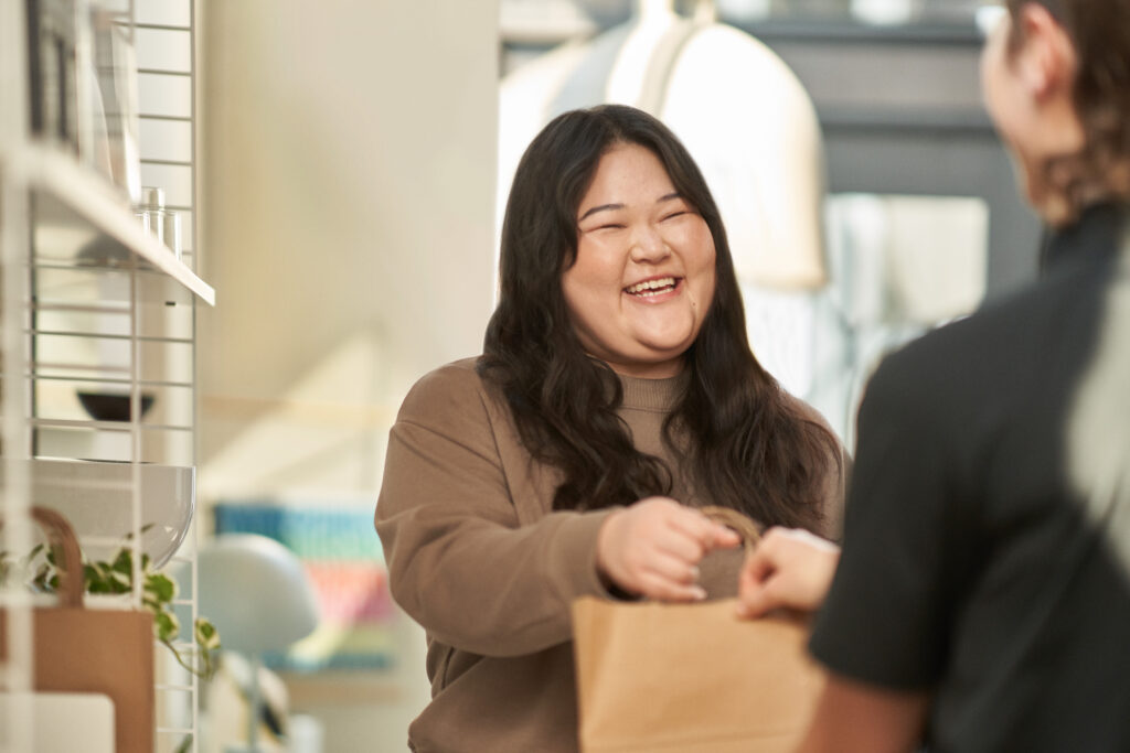 Photo of smiling female customer picking up order in-store.
