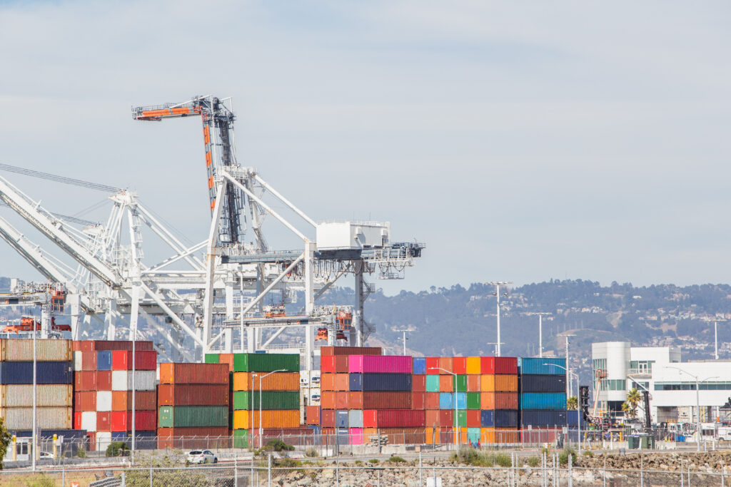 Photo of shipping port featuring cranes and stacks of containers.