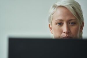 Close-up of a woman focused on her computer screen.