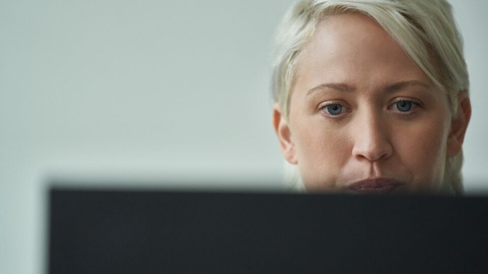 Close-up of a woman focused on her computer screen.