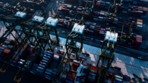 Photo of an aerial view of cranes unloading cargo containers in Singapore shipyard.