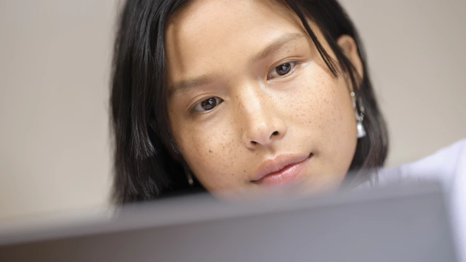 A close-up of a woman looking at a computer.