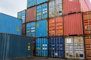 Photo of colorful shipping containers stacked in a shipyard.