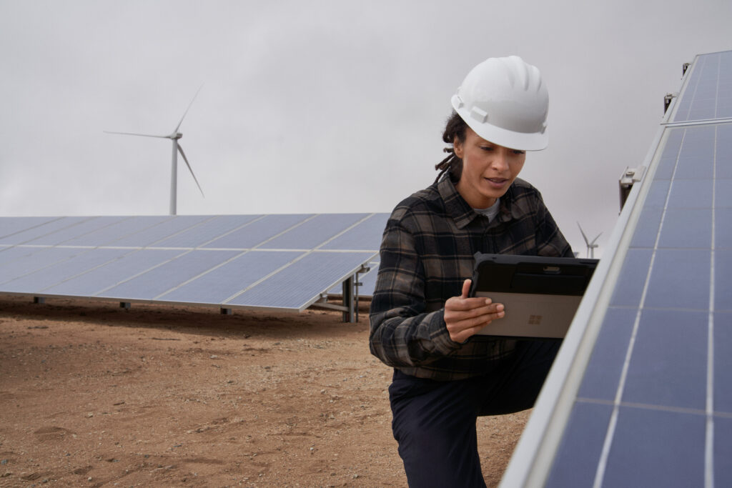 Photo of a field technician working on a solar panel farm.