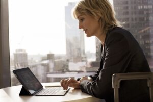 Business woman in remote office working on laptop.
