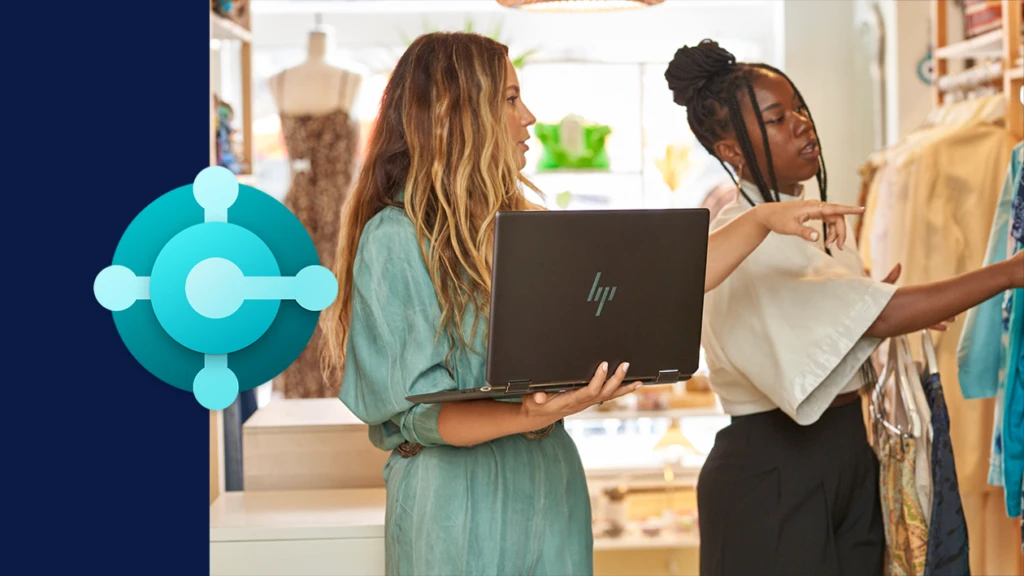 Two retail workers using a computer to help take inventory, accompanied by the Business Central icon