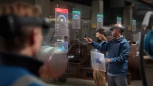 Mehrere Männer arbeiten an virtuellen Bildschirmen und tragen eine HoloLens