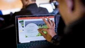 Ein Laptop auf der eine Hand ein Bild mit der Aufschrift "Sustainability" vergrößert.