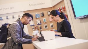 A frontline retail mobile phone employee helping a customer
