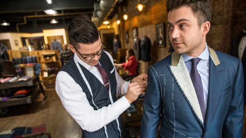 Tailor adjusting a suit jacket