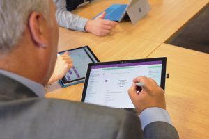 Close up of Jon and a co-worker in a meeting on Surface devices with OneNote