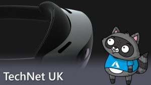 A photo of the HoloLens 2, with a picture of Bit the Raccoon standing on the right of it, looking up at it.