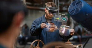 HoloLens を装着して工場生産ラインで部品の性能をバーチャル確認する男性