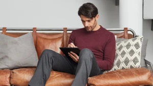 man sitting on the couch using a tablet