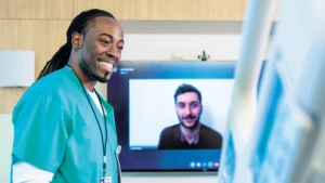 Nurse smiling at a man in Microsoft Teams video call