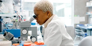 Mulher em um laboratório olhando no microscópio