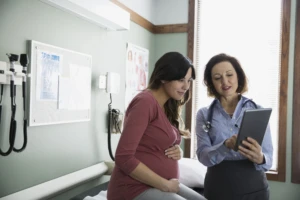 Doctor and pregnant woman looking at tablet