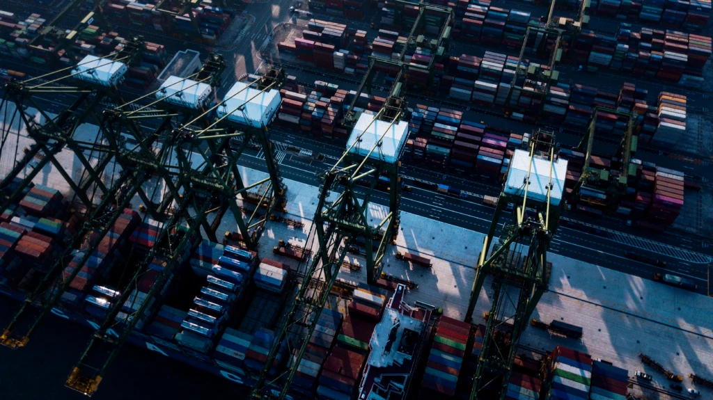 Aerial view of cranes unloading cargo containers in shipyard