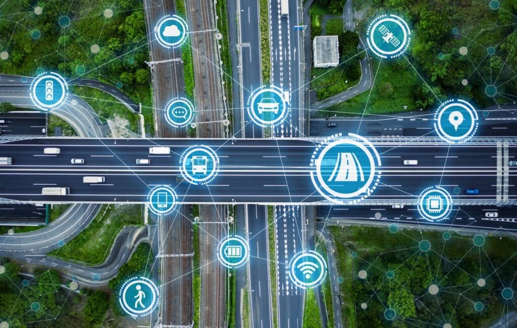 Top-down view of a highway system with social infrastructure and communication technology symbols overlayed to visualize connectivity.