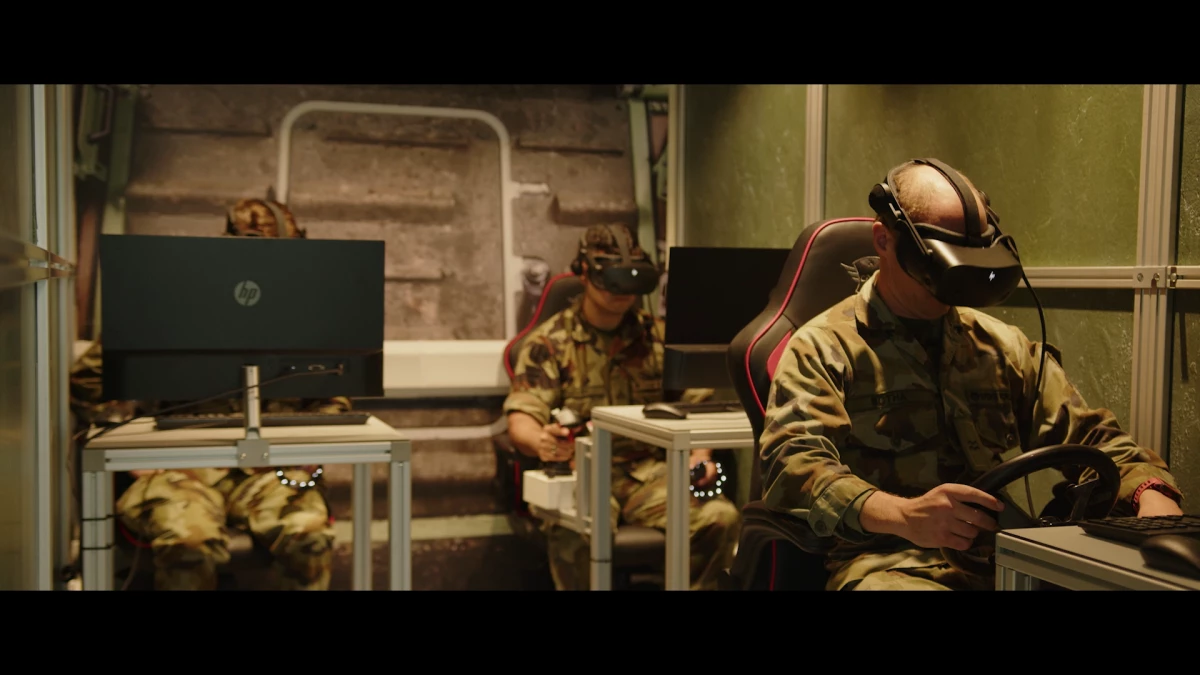 3 soldiers sitting at desks with VR goggles on immersed in training simulations developed by VRAI