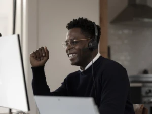 Adult male inside using Microsoft Modern USB Headset. Microsoft Viva helps improve the employee experience.