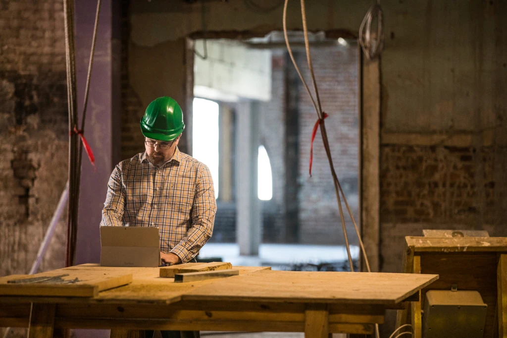 A man sitting at a table in a construction site.