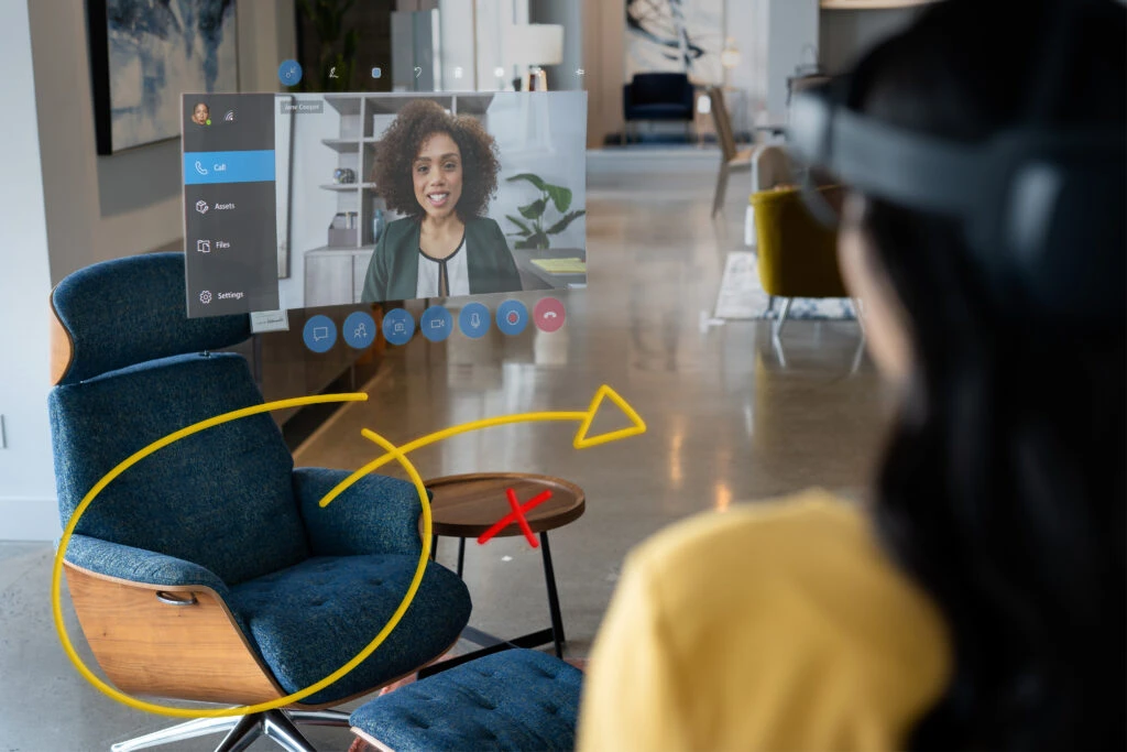 A retail manager using Dynamics 365 Remote Assist on HoloLens 2 to collaborate with a remote design expert to display in-store items with the help of 3D annotations.