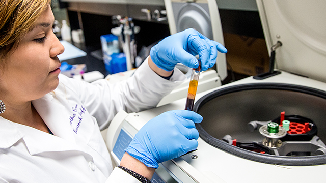 lab researcher examining a test tube.