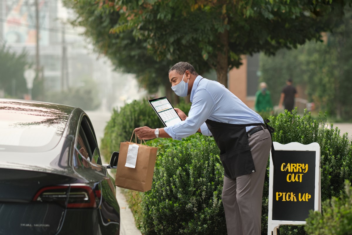 Curbside order pickup from a restaurant or coffee shop. Order in Excel and OneDrive. Microsoft 365 and Surface. Small Business Male, food, restaurant, coffee, Covid, pandemic, masks, car, order.