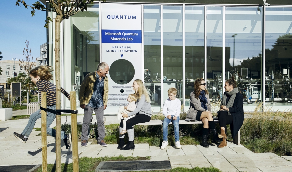 Adults and children congregating outside the the glass walls of the Quantum Materials Lab