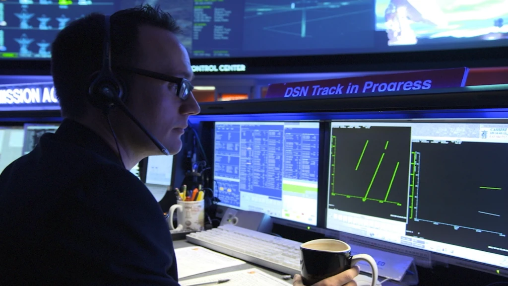 An image of a person sitting in mission control at NASA